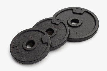Black weight plates on white background. Gym equipment