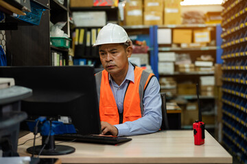 Warehouse managers working on computer in a warehouse.