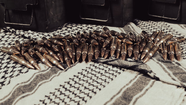 .308 caliber ammunition and ammunition containers on a fabric background (keffiyeh)