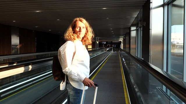 Stockholm, Sweden A woman rides an escalator at the Arlanda airport with a carry-on bag.