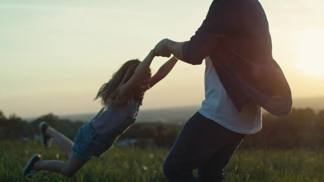 Dad playing with daughter at the meadow during the sunset. Shot with RED helium camera in 4K.  