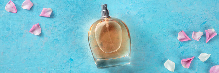 Rose fragrance panorama with fresh flower petals, top shot on a blue background, a minimalist...