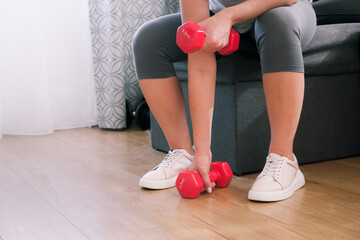sportswoman practicing aerobic with dumbbells. woman lifting weights and working out at home.
