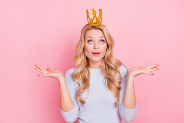 Photo of stunning young lady shrug shoulders look up golden crown isolated on pink color background