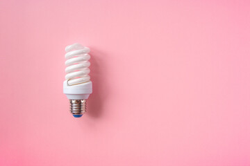 Energy saving light bulb on a pink background. Economical consumption of electricity. The concept of nature conservation