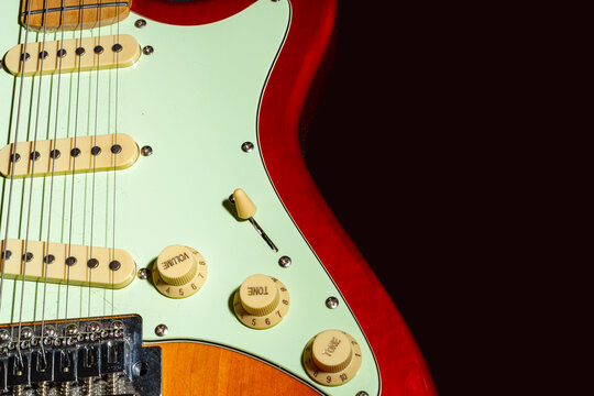 Electric guitar on a black background, isolated on a dark background in close-up. Selective focus.