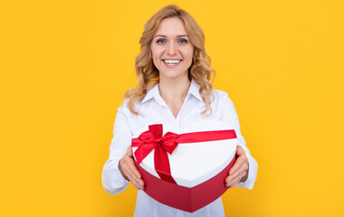 positive woman hold present heart box on yellow background