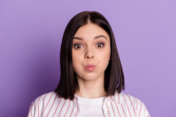 Photo of young woman pouted cheeks fooling hold breath joke grimace isolated over violet color...