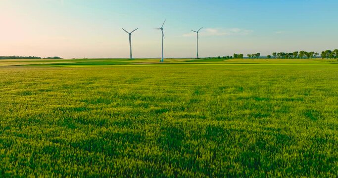 Aerial drone view of wind power turbines, part of a wind farm. Wind turbines on green field in countryside. Wind power plant..