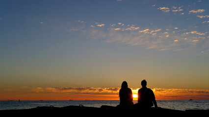 Lovers in front of a summer sunset on the Baltic bay, Mangalsala, lighthouse