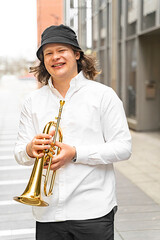 Portrait of young caucasian blond cheerful smiling man in white shirt and hat playing funky jazz on...