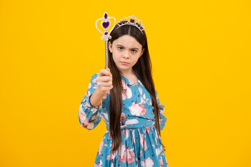 Portrait of girl princess in tiara holding magic wand. Teenager queen with golden crown.
