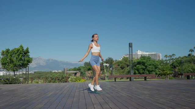 Woman Jumps With Two Skipping Ropes And Does Exercises On Beach. High Quality 4k Footage