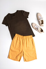 Still life of women's clothing: T-shirt and shorts, shoes, top view layout