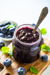 Blueberry jam in the glass jar with fresh berries. Homemade dessert,