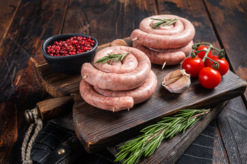 Bavarian Raw spiral sausages on a wooden board. Wooden background. Top view
