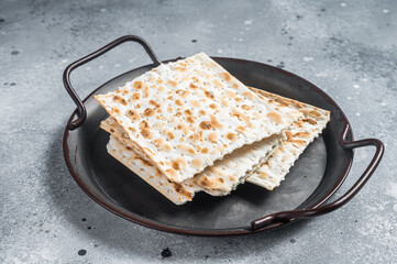 Pieces of matzah in a vintage steel tray. Gray background. Top view