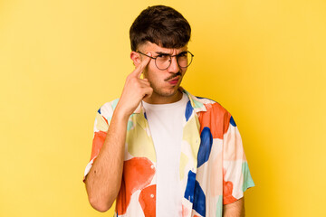 Young caucasian man isolated on yellow background pointing temple with finger, thinking, focused on a task.