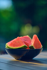 Watermelon Slices in black bowl on table. High quality photo