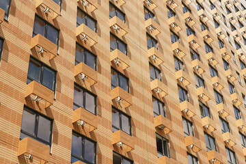 Facade of a new multi-apartment high-rise residential building with windows background. Architecture and design of a typical development of a new city district. Construction, developer, housing