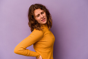 Young caucasian woman isolated on purple background suffering a back pain.