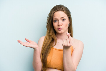 Young caucasian woman isolated on blue background showing that she has no money.