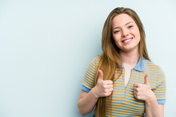Young caucasian woman isolated on blue background smiling and raising thumb up
