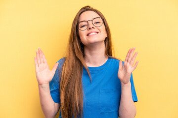 Fototapeta premium Young caucasian woman isolated on yellow background laughs out loudly keeping hand on chest.