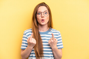 Young caucasian woman isolated on yellow background pointing upside with opened mouth.