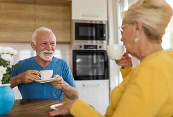 Senior man and woman drinking coffee at home