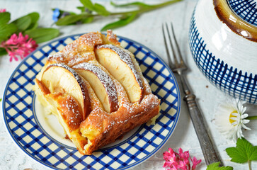 Pie with pieces of apples on a blue plate