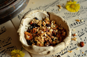 Homemade granola in a rustic bowl placed on old notes
