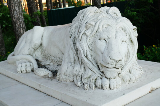 Sculpture of a sleeping lion in the park close-up.
