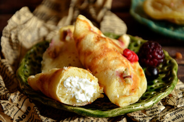 Sweet dumplings with cheese and raspberries on a green plate