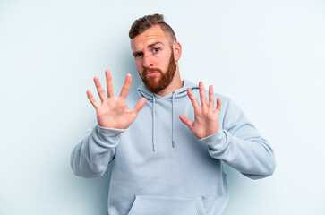 Young caucasian man isolated on blue background rejecting someone showing a gesture of disgust.
