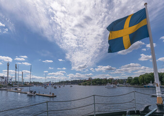 Stern of the old steam ice breaker St Erik, Swedish flag, sailboats and commuter boats, a sunny...