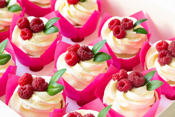 Cupcakes  decorated with fresh raspberry  in delivery paper box. Sweet food delivery. Fruits cup cakes, menu design or recipe background
