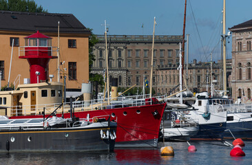Fore of old lighthouse ship, transport sips and fishing boats at the island Skeppsholmen and the...