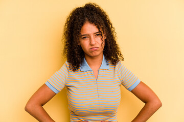 Young Brazilian woman isolated on yellow background sad, serious face, feeling miserable and displeased.