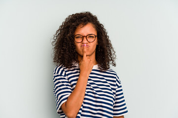 Young Brazilian woman isolated on blue background thinking and looking up, being reflective, contemplating, having a fantasy.