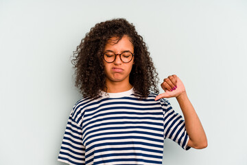 Young Brazilian woman isolated on blue background showing a dislike gesture, thumbs down. Disagreement concept.