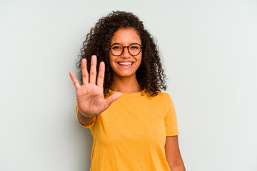Young Brazilian woman isolated on blue background smiling cheerful showing number five with fingers.