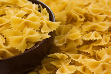 Raw farfalle pasta in a plate close-up. Pasta in the studio