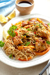 Asian style, stir fry noodles with chicken meat and vegetable, dark background. homemade food