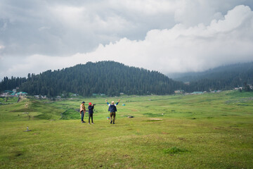 Fototapeta na wymiar 3 friends in the mountains, and photo depicts the peace and heavenly beauty that prevails in the valley of Kashmir which has been engulfed by the terrorism, Gulmarg, Kashmir, India.