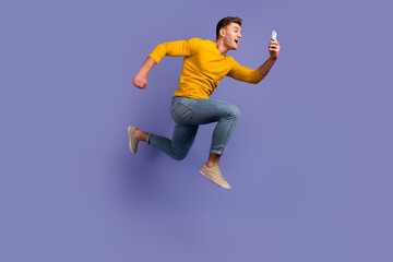 Full size profile side photo of young guy jump run use mobile button download isolated over violet...