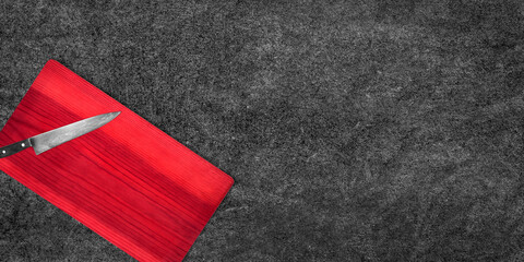 Topview of Cooking Knife and Red Cutting Board on Dark Background