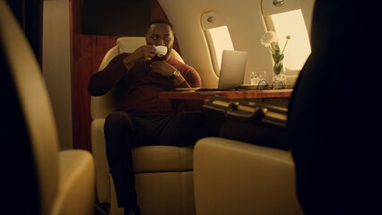 Fototapeta premium Successful businessman browse online at airplane window. Ceo on business travel