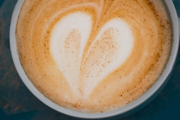 Cup of cappuccino with latte art in the shape of a heart. Close up