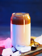 Dalgona coffee, a sweet whipped Korean popular drink. neon blue background